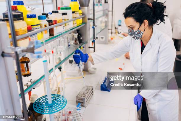 focused female biochemist making new discoveries at the innovative laboratory while working on a covid-19 vaccine - rna stock pictures, royalty-free photos & images