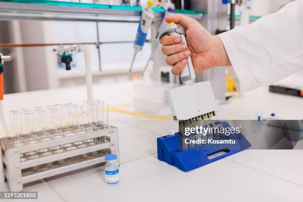 biochemist scientist using a model kit while testing few prototypes of a covid-19 vaccine - pipette stock pictures, royalty-free photos & images