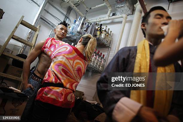 In a photo taken on October 15, 2011 a makeup artist attends to 'Mr. Gay Hong Kong' winner Jimmy Wong Chun prior to his appearance in the final...