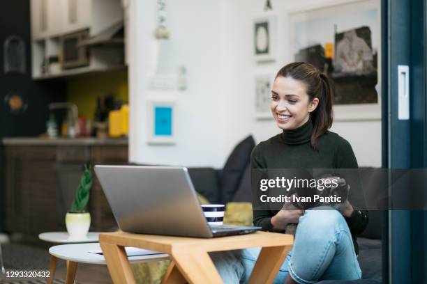 beautiful happy caucasian woman working from home using a laptop - social media marketing stock pictures, royalty-free photos & images