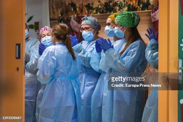 Health workers applaud after Josefa Perez was the first woman to be vaccinated in Catalonia, during the first day of vaccination in Spain against...
