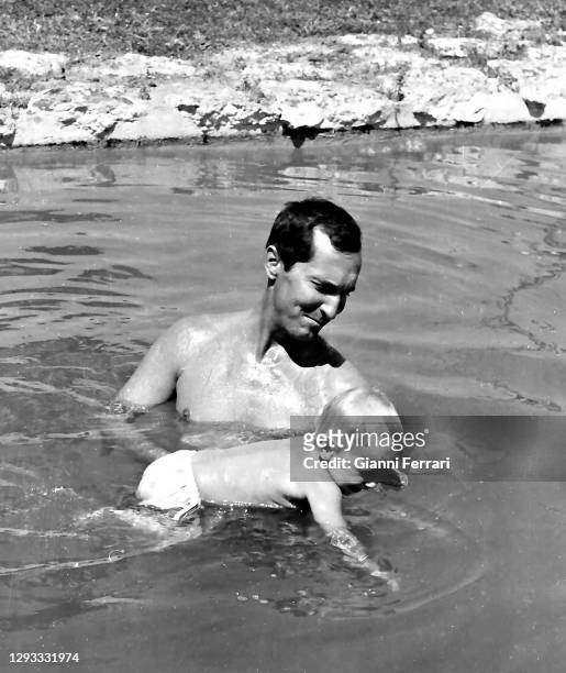 Spanish bullfighter Luis Miguel Dominguin in the pool of his house of Somosaguas, with his daughter Paola, Madrid, Spain, 1961.