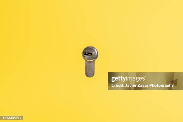 lock on yellow background - buco della serratura foto e immagini stock