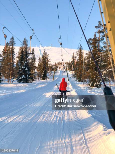 a young woman skier climbs the mountain on a ski lift. snow-covered ski slope. snowy, winter landscape and a lot of snow. - woman on ski lift stock pictures, royalty-free photos & images