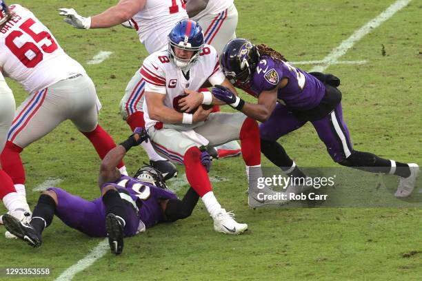 Quarterback Daniel Jones of the New York Giants is sacked by Chris Board and cornerback Tramon Williams of the Baltimore Ravens during the fourth...