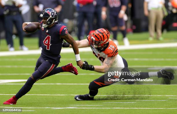 Quarterback Deshaun Watson of the Houston Texans scrambles against defensive end Margus Hunt of the Cincinnati Bengals during the fourth quarter of...