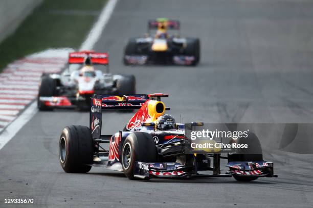 Race winner Sebastian Vettel of Germany and Red Bull Racing leads from second placed Lewis Hamilton of Great Britain and McLaren and third placed...