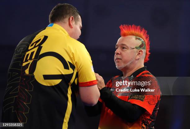 Gabriel Clemens of Germany and Peter Wright of Scotland congratulate each other after there third round match against Peter Wright of Scotland during...