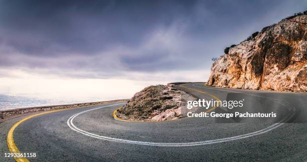 hairpin cuve panorama and dramatic sky - hairpin curve stock-fotos und bilder