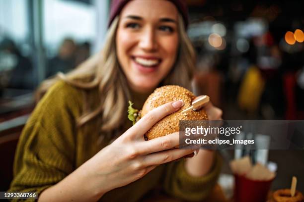 heerlijke hamburger - woman eating burger stockfoto's en -beelden