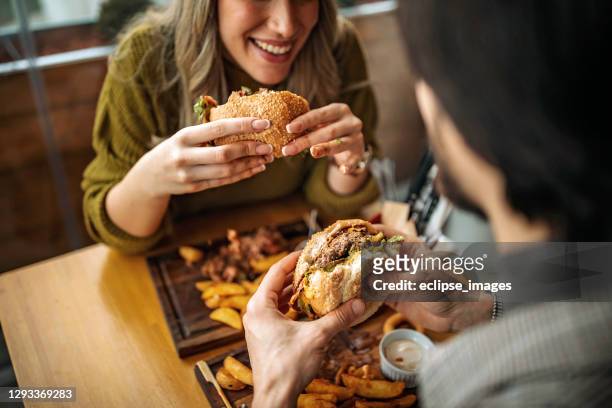 hamburger per due - adults eating hamburgers foto e immagini stock