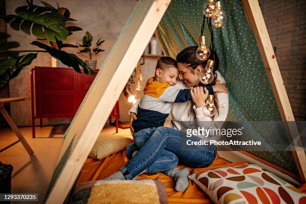 mère et fils détendant dans une tente dans le salon - teepee photos et images de collection