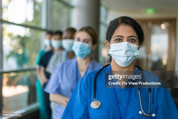 female doctor leading team of medical professionals during covid-19 pandemic - hospital safety stock pictures, royalty-free photos & images