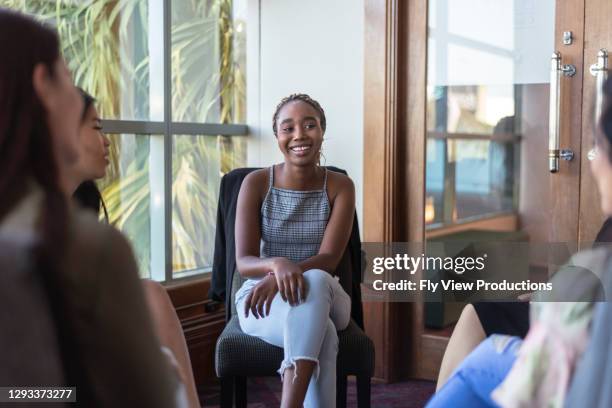 hopeful woman in group therapy session - community australia stock pictures, royalty-free photos & images