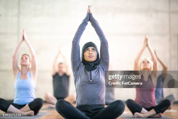 woman wearing hijab in yoga class - 19 years stock pictures, royalty-free photos & images