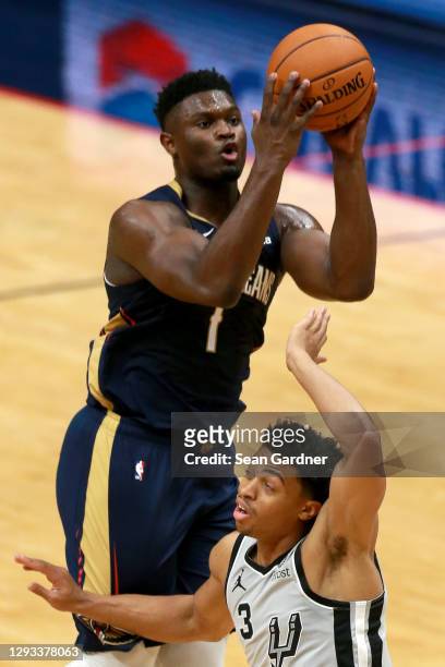 Zion Williamson of the New Orleans Pelicans shoots over Keldon Johnson of the San Antonio Spurs during a game at Smoothie King Center on December 27,...