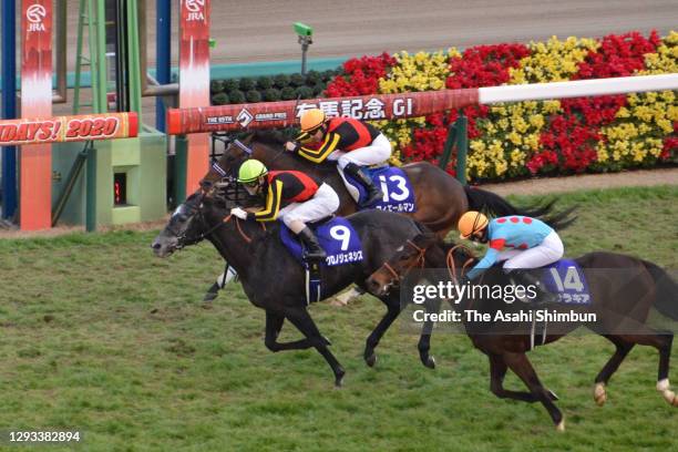 Jockey Yuichi Kitamura riding Chrono Genesis crosses the finish line to win the Arima Kinen at the Nakayama Racecourse on December 27, 2020 in...