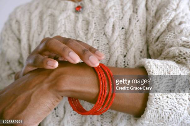 woman wears red bangles - extreme close up woman stock pictures, royalty-free photos & images