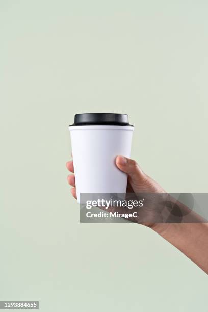 hand holding a reusable coffee cup - coffe to go becher stock-fotos und bilder