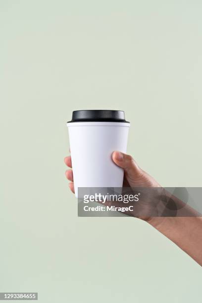 hand holding a reusable coffee cup - cup stockfoto's en -beelden