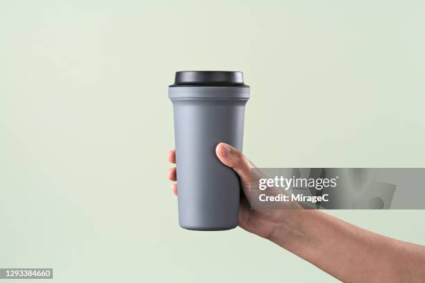 hand holding a reusable coffee cup - drinks flask stock pictures, royalty-free photos & images