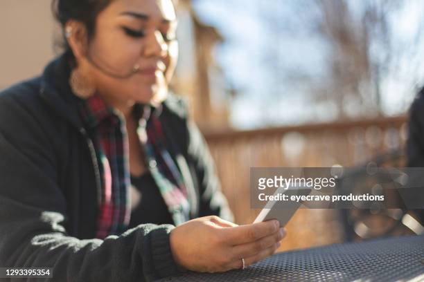 generation z female of native american ethnicity using smart phone - co op stock pictures, royalty-free photos & images