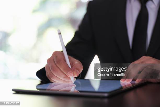 businessman signing digital contract on tablet using stylus pen - signing tablet stock pictures, royalty-free photos & images