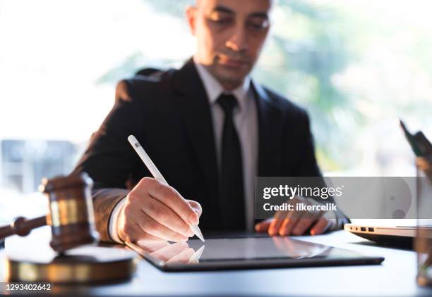 businessman signing electronic legal document on digital tablet - law imagens e fotografias de stock