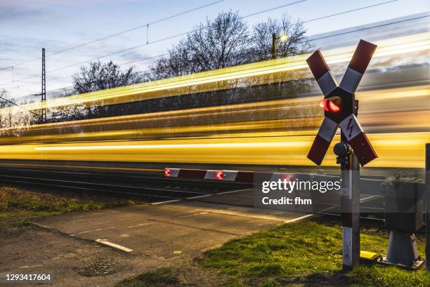 rail crossing with passing train - weichen gleise stock-fotos und bilder