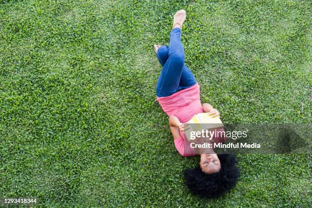 bird eye view of young woman holding book - read book outside young woman stock pictures, royalty-free photos & images