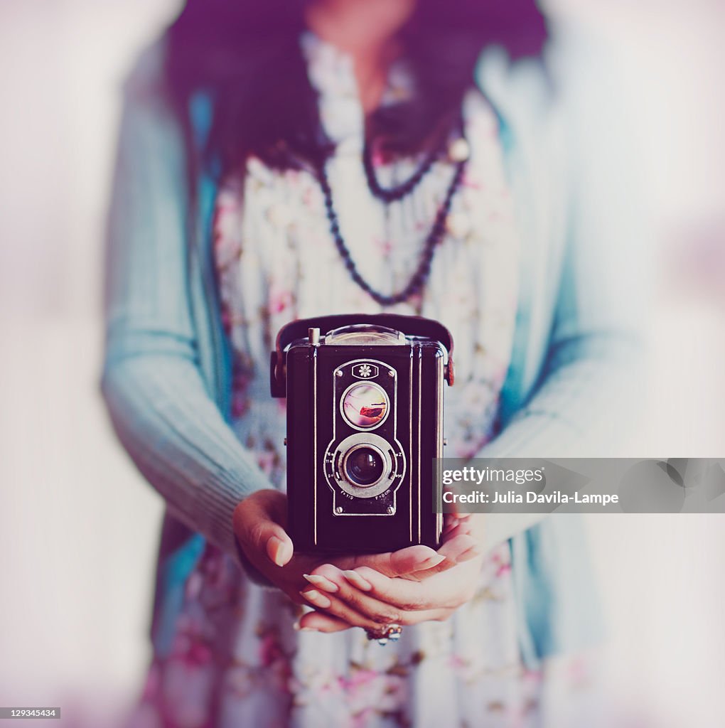 Young woman holding box camera