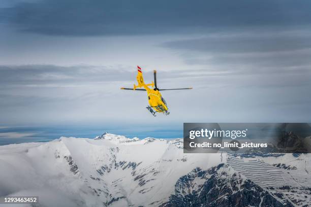 rettungshubschrauber in winterlandschaft in österreich - zillertal stock-fotos und bilder