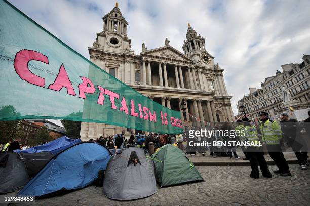 Banner reading 'Capitalism is Crisis' is displayed in front of St Paul's Cathedral in the city of London on October 16, 2011 as part of a global day...
