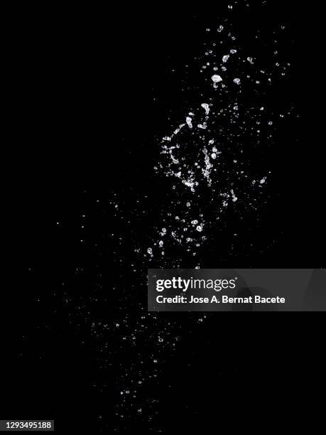 splashes, jet and drops of water in motion suspended in the air on a black background. - bubbles photos et images de collection