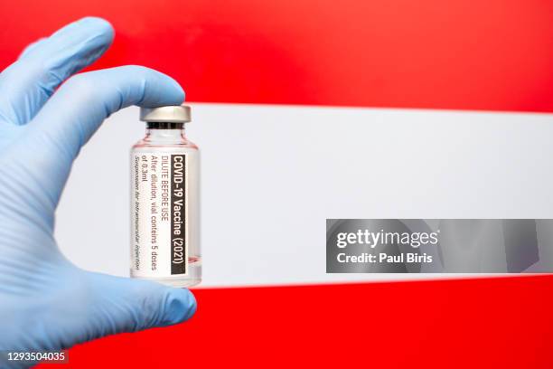 austria flag with coronavirus covid-19 concept. doctor with blue protection medical gloves holding a vaccine bottle. epidemic virus, cov-19, corona virus outbreaking - austria covid stock pictures, royalty-free photos & images