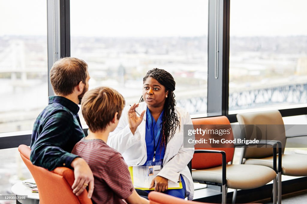 Female doctor talking to patient in hospital waiting room