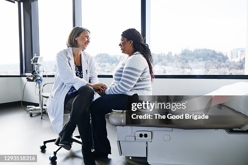 Smiling female doctor talking to woman in hospital Smiling female doctor talking to woman in hospital