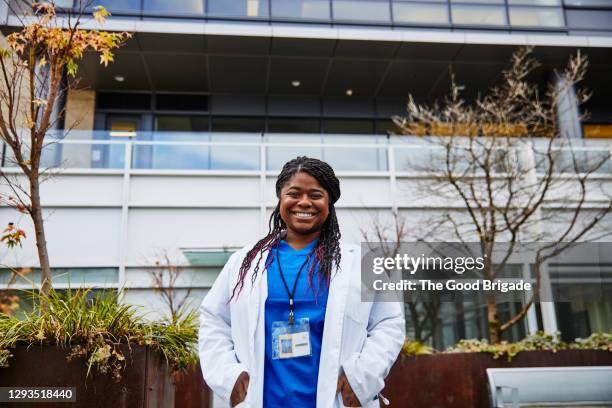 portrait of smiling female doctor in front of hospital building - blouse blanche femme photos et images de collection