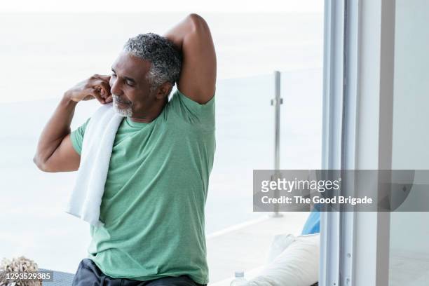 smiling mature man stretching in balcony - mature men stock pictures, royalty-free photos & images