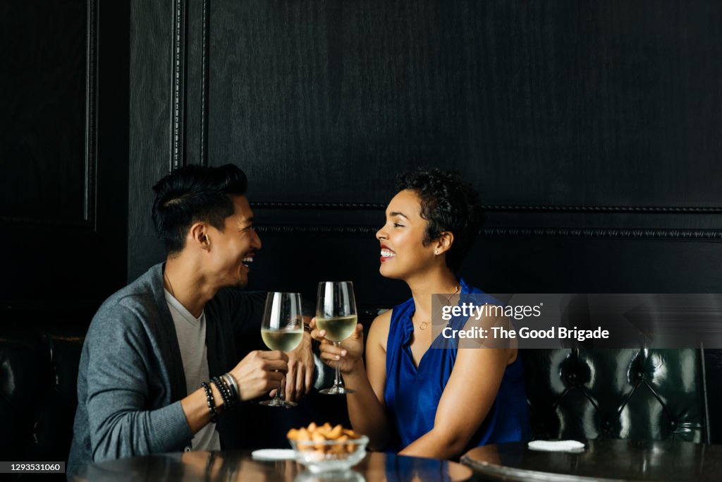 Couple toasting wine glasses at restuarant