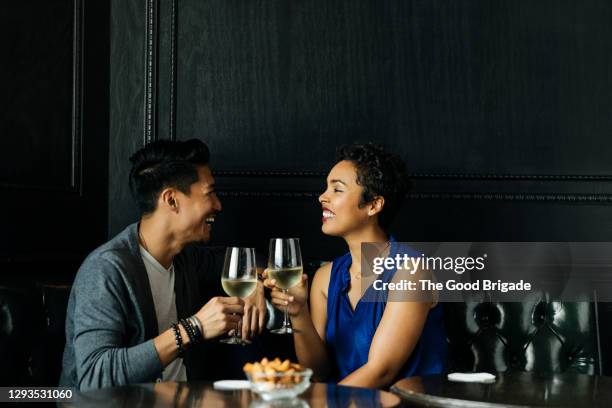 couple toasting wine glasses at restuarant - couples romance imagens e fotografias de stock