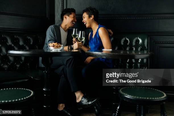 romantic couple enjoying drinks at table in restaurant - couples dating stock pictures, royalty-free photos & images