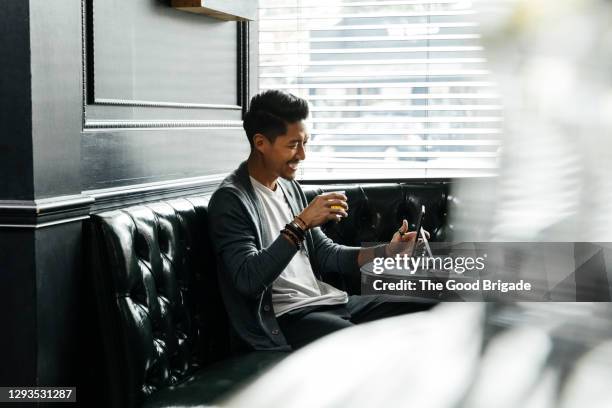 smiling man having video chat on digital tablet in restaurant - tablet alcohol stock pictures, royalty-free photos & images