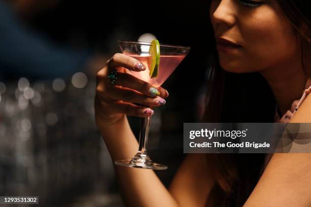 midsection of woman having drink at bar - cosmopolitan cocktail foto e immagini stock