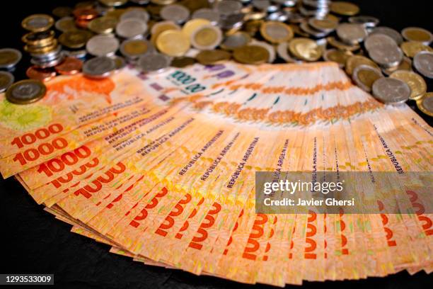 dinero en efectivo: pesos argentinos en billetes de 1000 y monedas - billetes stock pictures, royalty-free photos & images