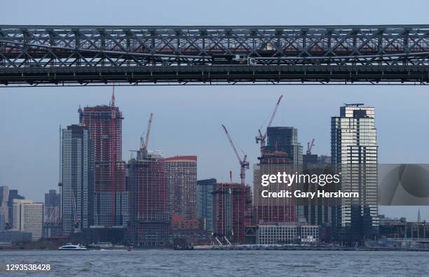 Truck crosses the Williamsburg Bridge above buildings being constructed in Long Island City on December 28, 2020 in New York City.