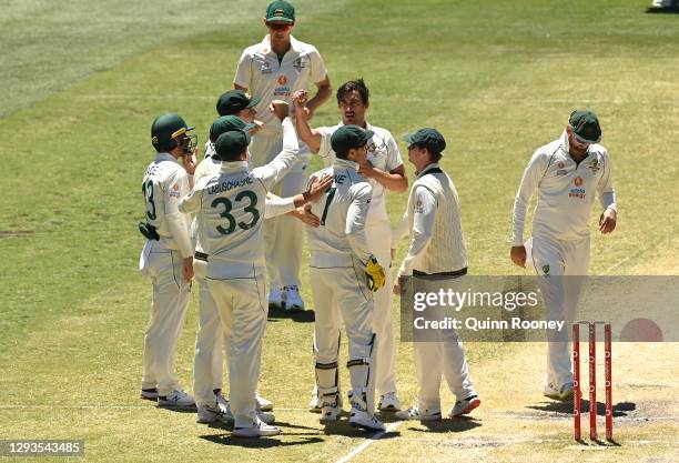 Mitchell Starc of Australia celebrates getting the wicket of Mayank Agarwal of India during day four of the Second Test match between Australia and...