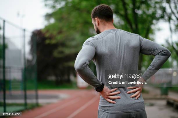 運動員在戶外公園背痛 - 下背部痛 個照片及圖片檔