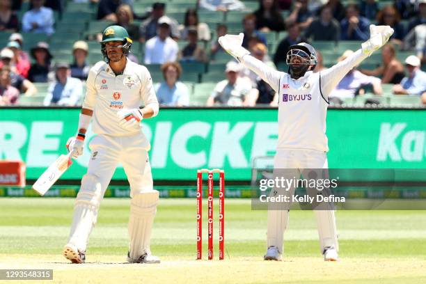 Rishabh Pant of India and Mitchell Starc of Australia react during day four of the Second Test match between Australia and India at Melbourne Cricket...