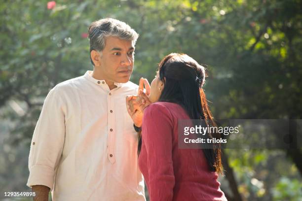 couple having an argument at park - fighting stock pictures, royalty-free photos & images